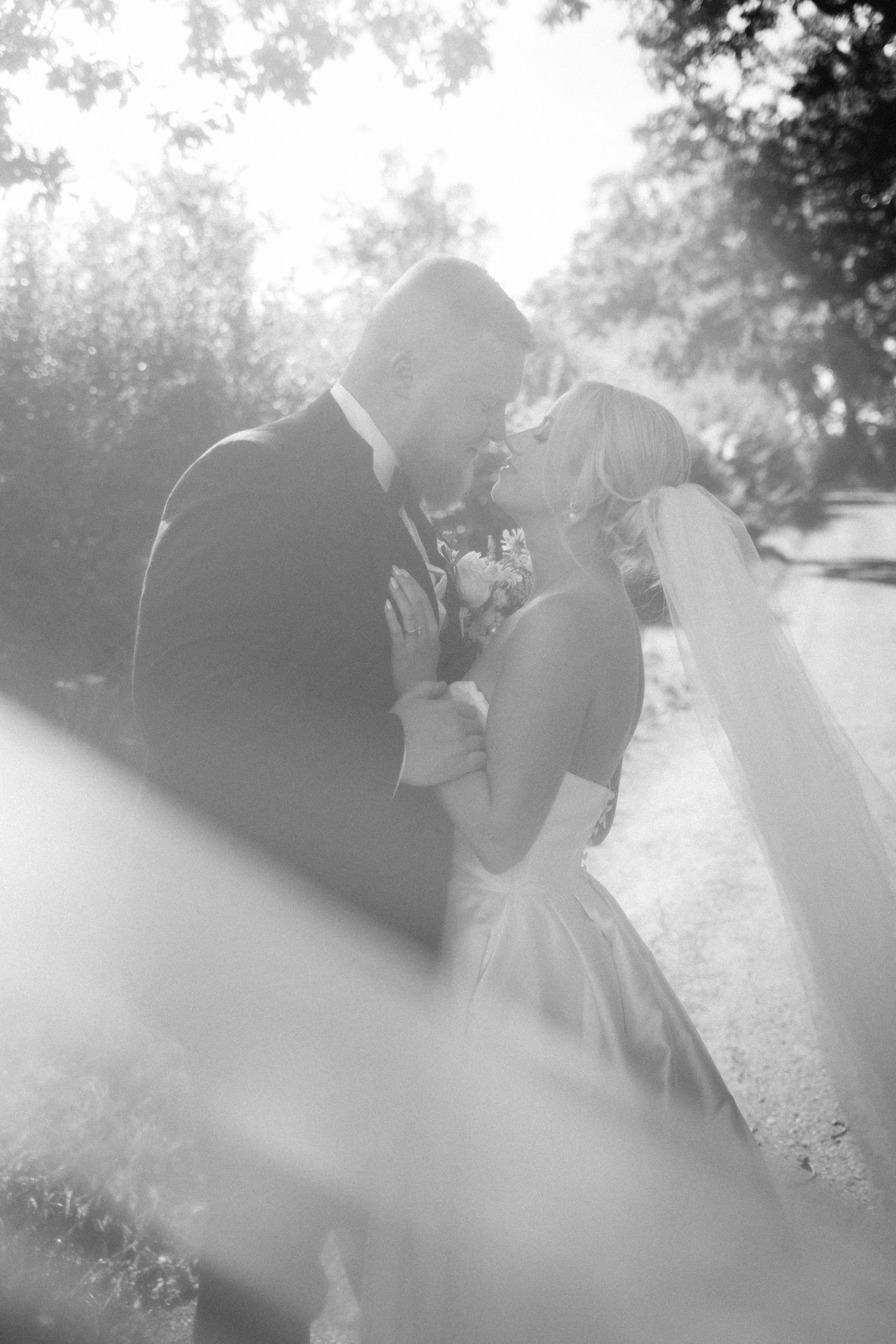 Romantic black and white wedding photo sequence showing a couple embracing in soft sunlight.