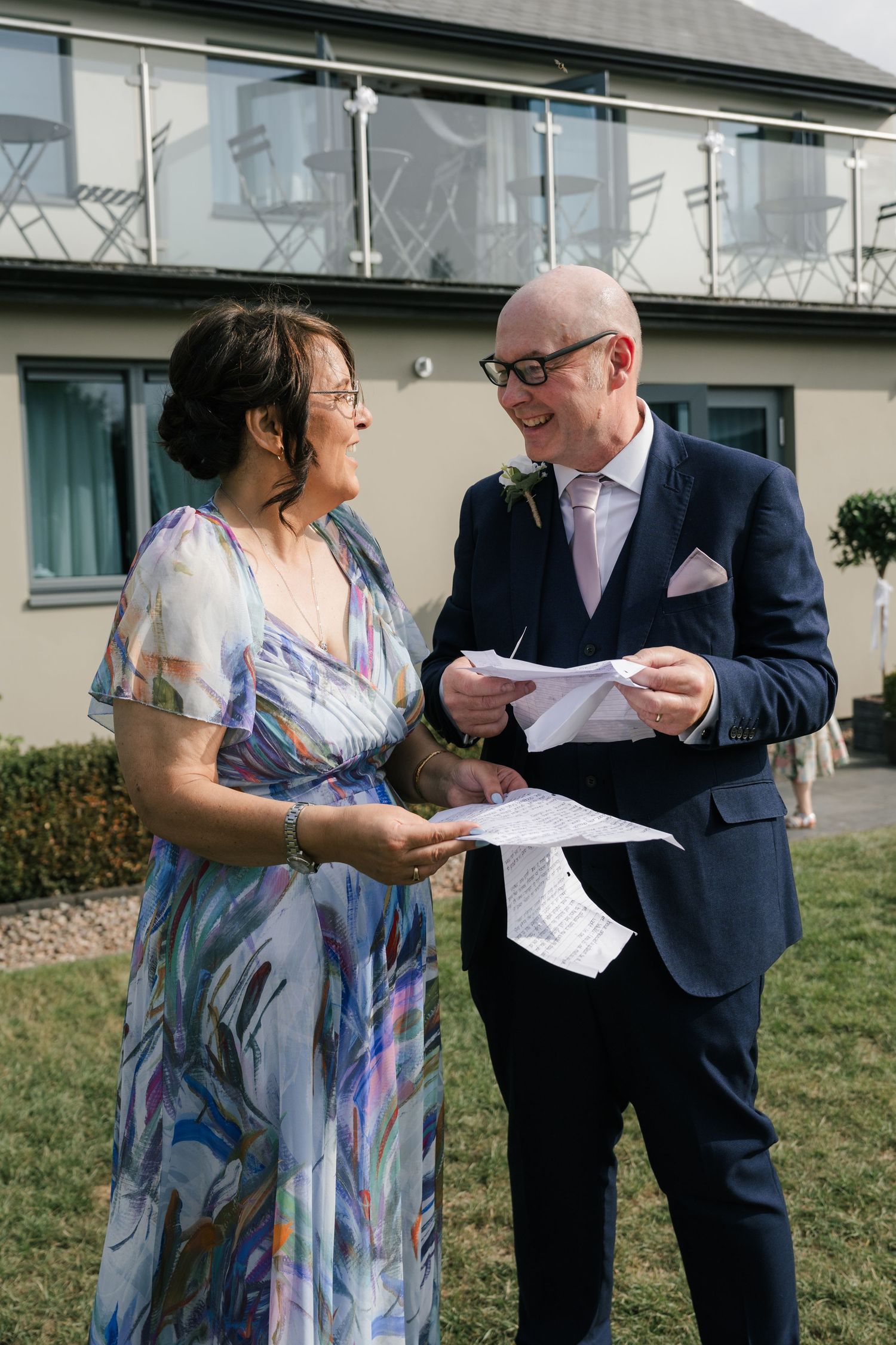 Two people in formal attire examine paperwork together outside a building in a series of four sequential photos.
