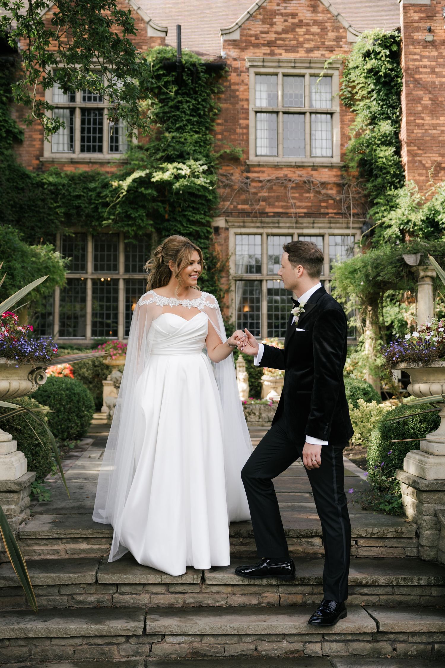 Progressive wedding photos capturing a couple's joyful interaction on stone steps with a historic building facade behind them.