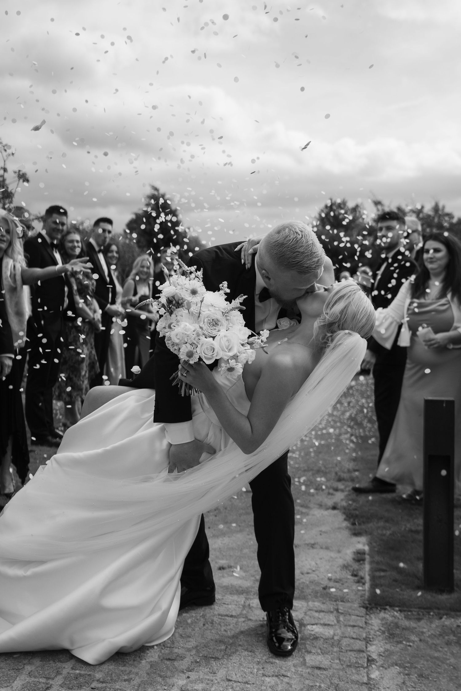 A joyful wedding celebration sequence shows the couple dancing amid falling confetti while guests look on at an outdoor venue.