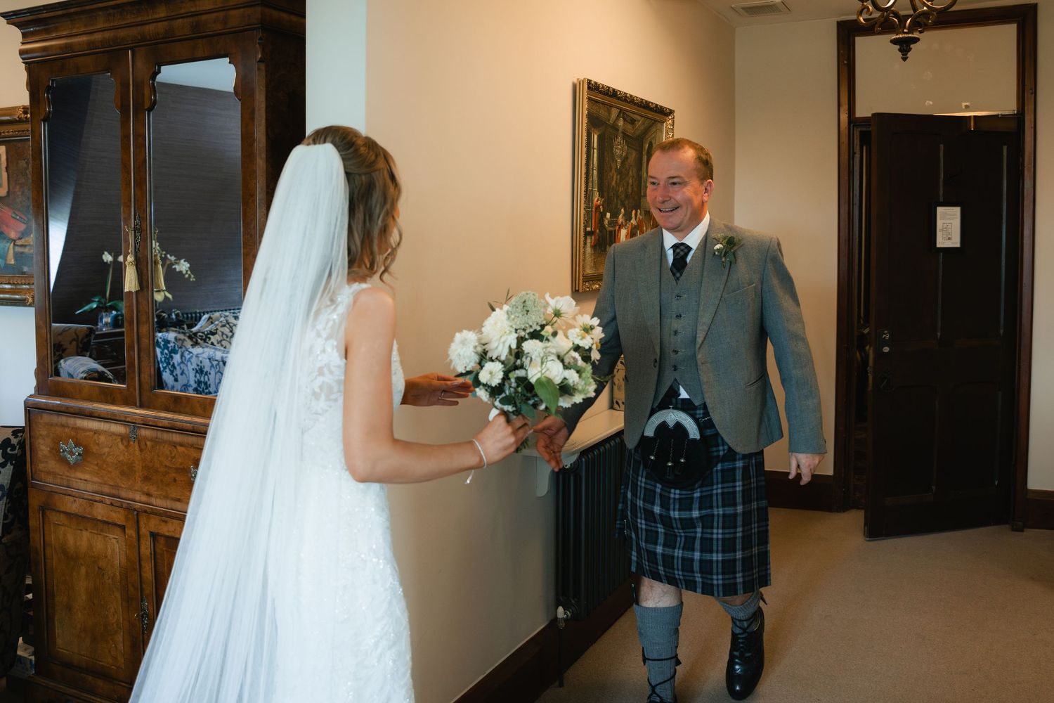 A wedding party stands in a church hallway with bridesmaids in burgundy dresses and groomsmen in suits.
