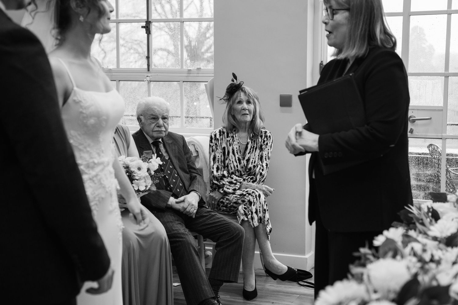 Black and white candid wedding photographs showing emotional moments during a ceremony and reception.