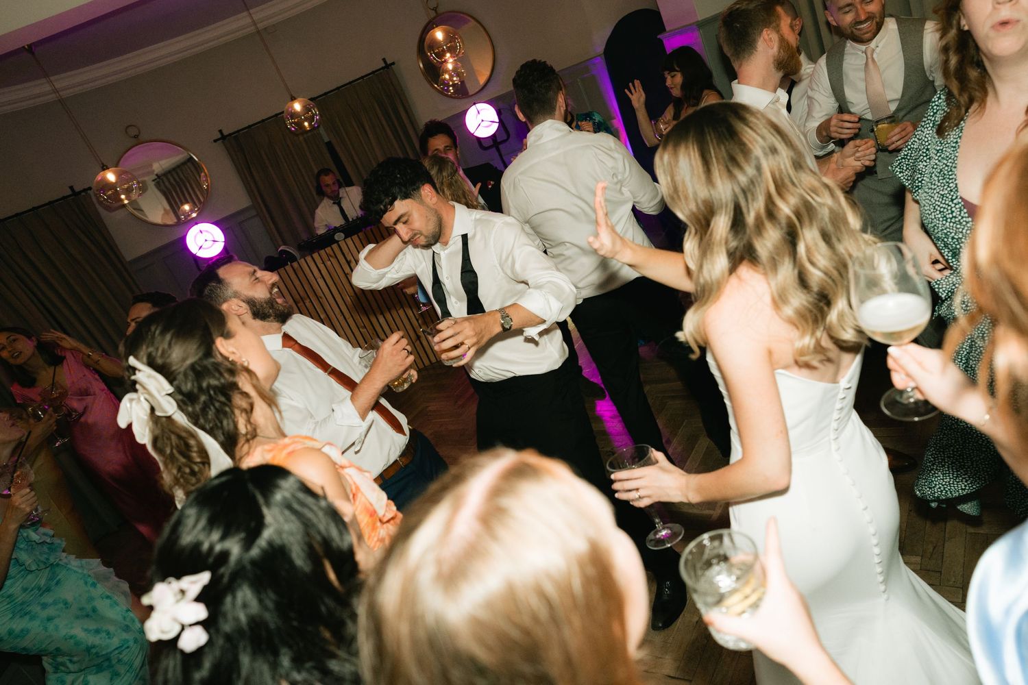 People dancing and enjoying themselves at a dimly lit nightclub or party venue.