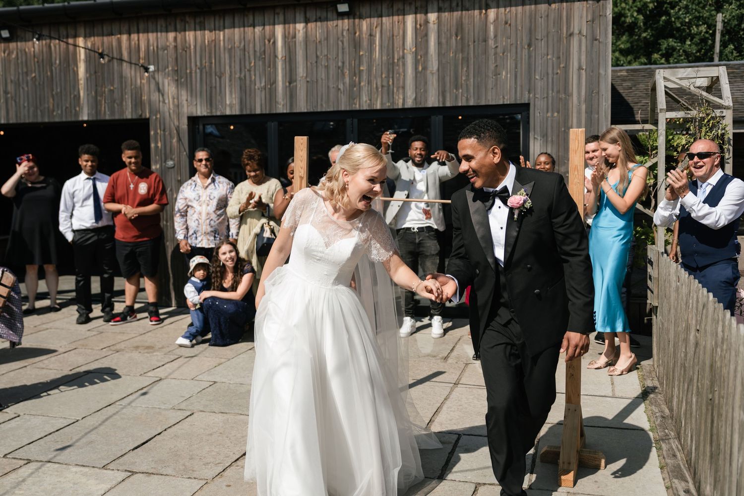 Wedding celebration with guests outside rustic barn venue.