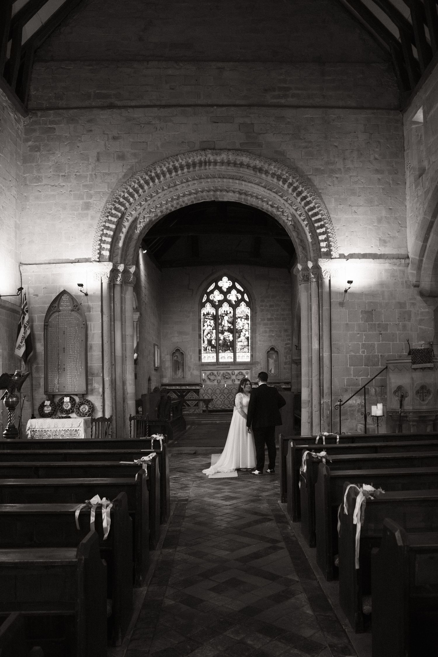 A dramatic black and white photo series showing a wedding ceremony inside a historic stone church with gothic architecture.