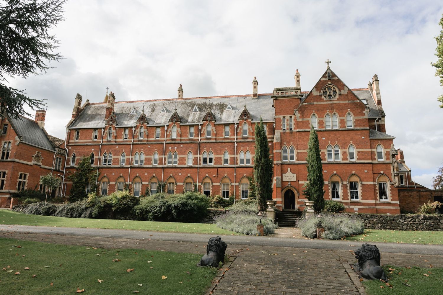 Historic red brick Victorian building with ornate architecture and landscaped grounds at Stanbrook Abbey in Worcester.
