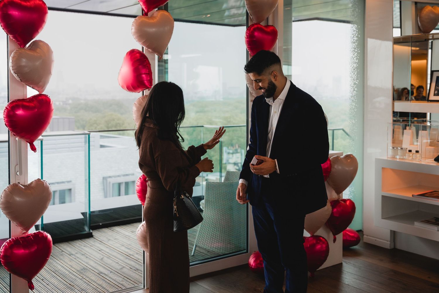 Modern interior space decorated with red heart-shaped balloons for a romantic celebration.