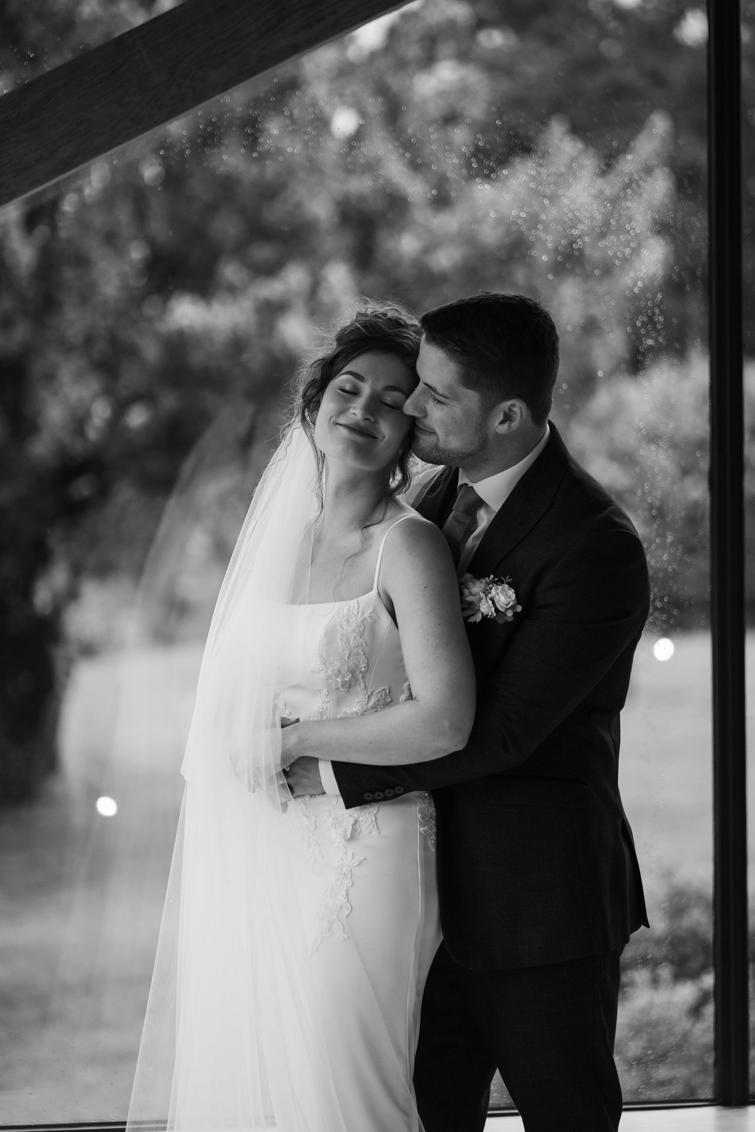 A romantic black and white wedding photography series showing tender moments between newlyweds in an outdoor setting.