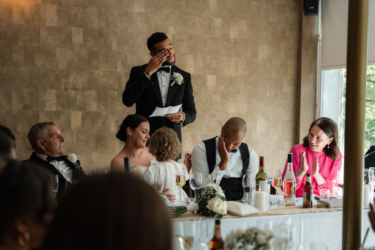 Wedding reception venue with stone walls and guests seated at decorated tables.