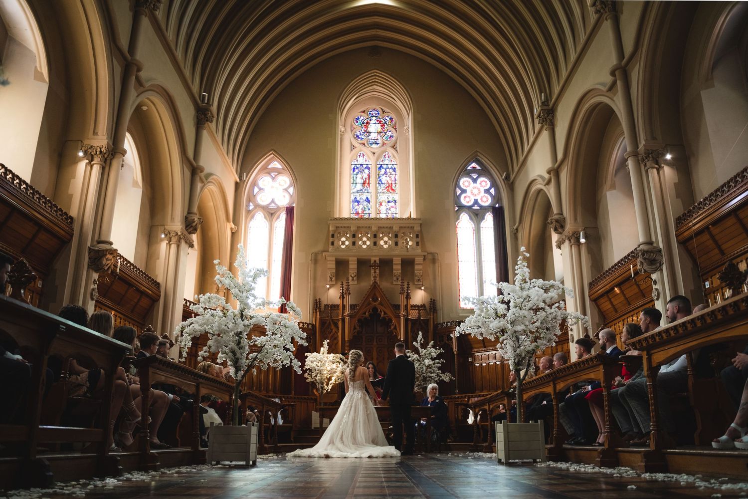 A panoramic sequence of wedding ceremony moments inside a grand Gothic church with stained glass windows and arched architecture.
