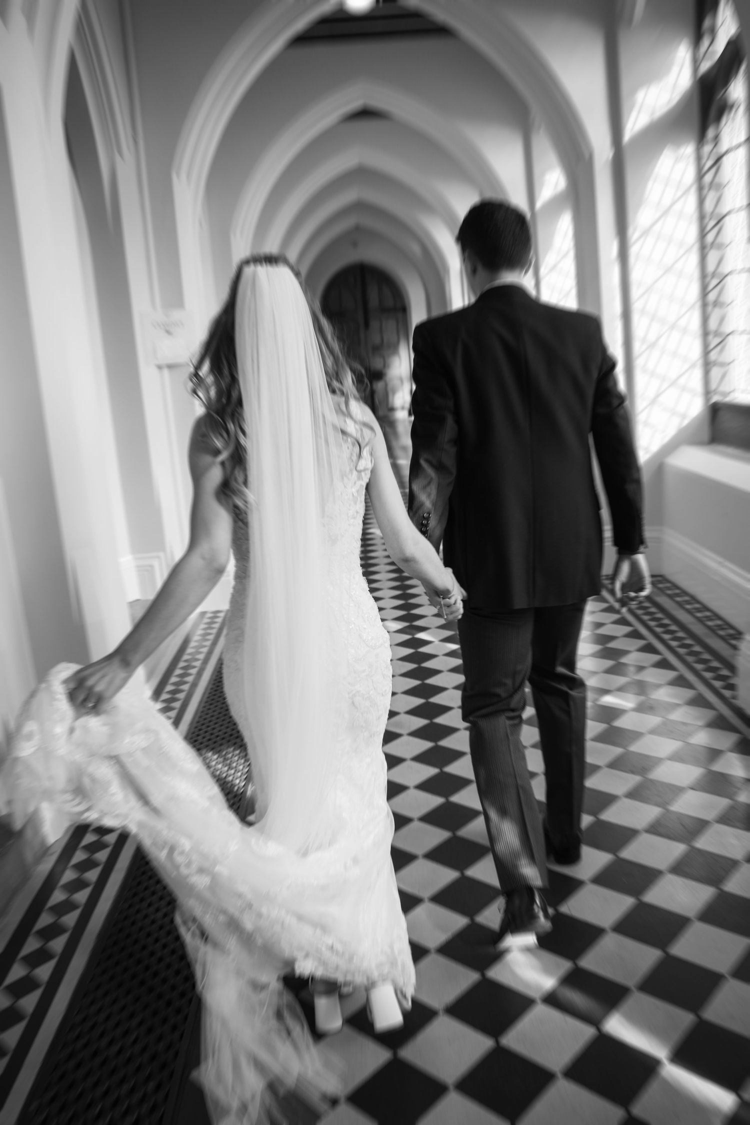Artistic black and white photo series showing couple walking on checkered floor in elegant hallway.