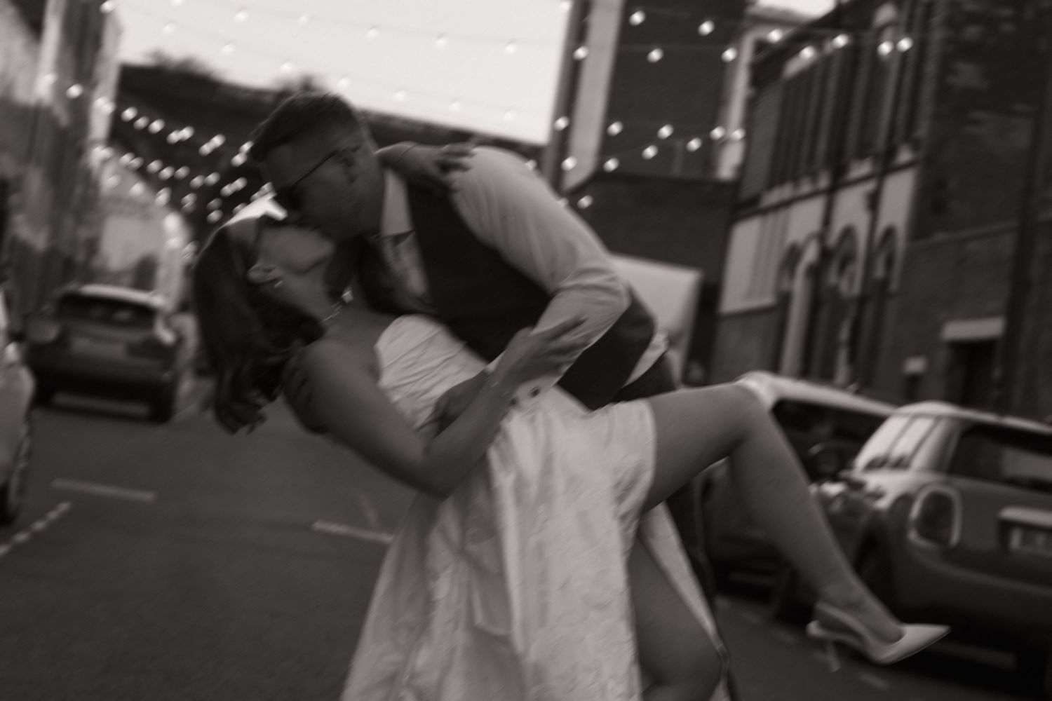 A series of black and white photos showing couples dancing and embracing at what appears to be a wedding celebration.