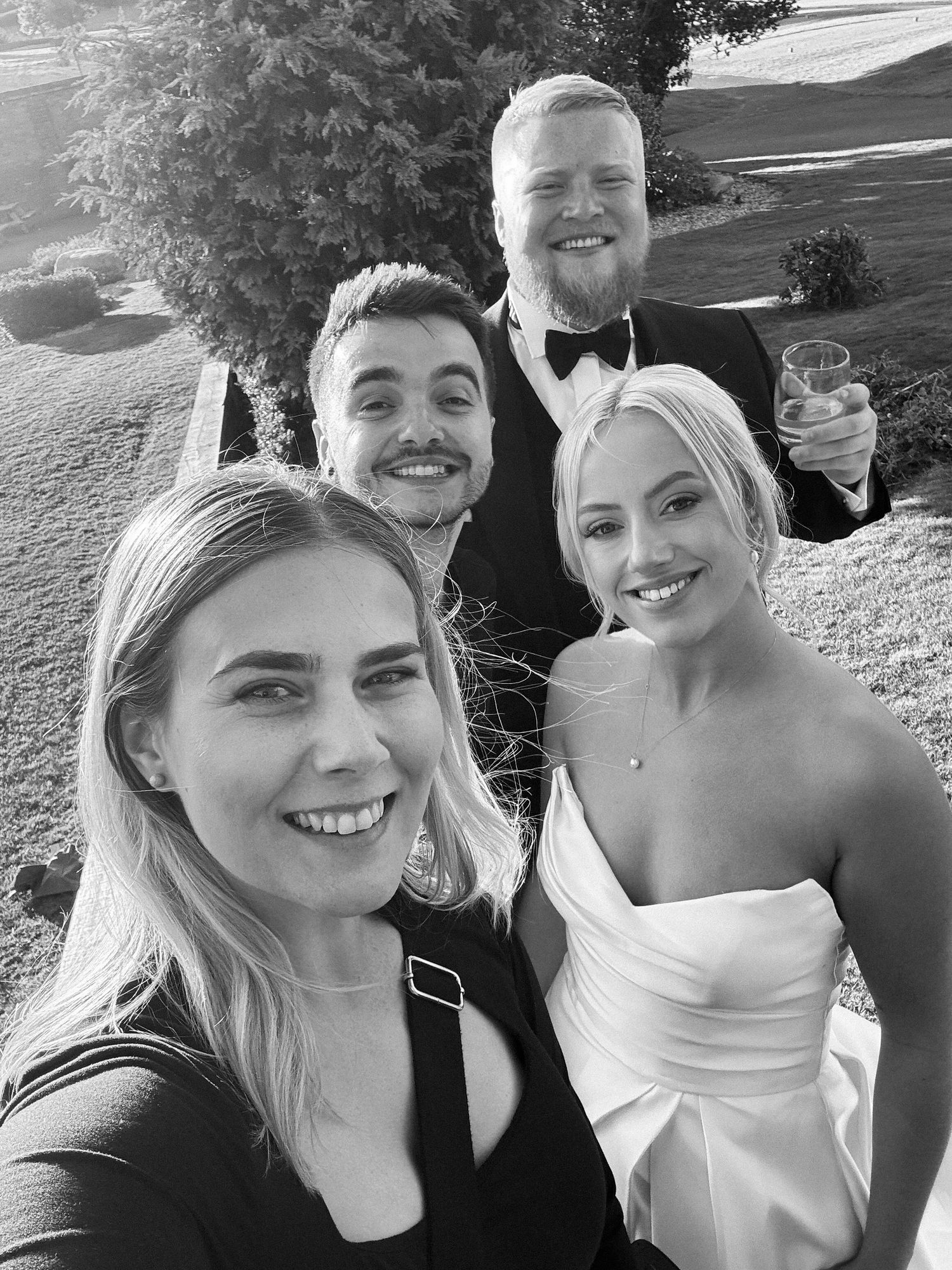 Four black and white selfie photos showing a couple smiling together outdoors.