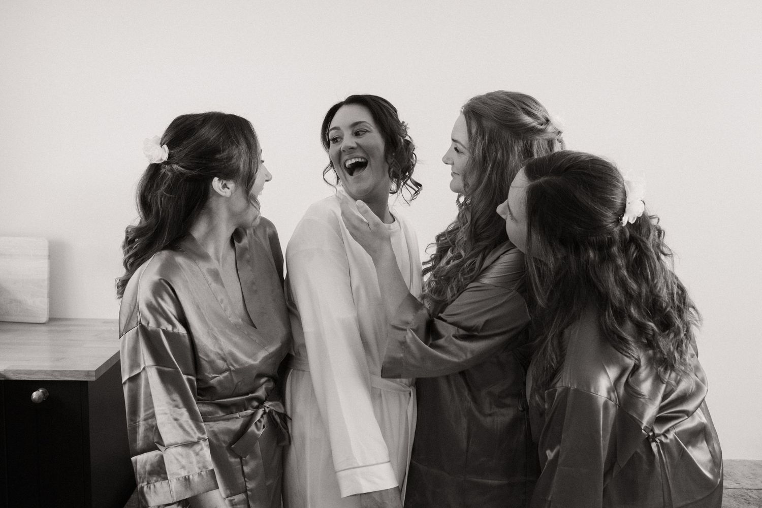 A series of black and white candid photos showing people laughing and embracing during a joyful celebration.