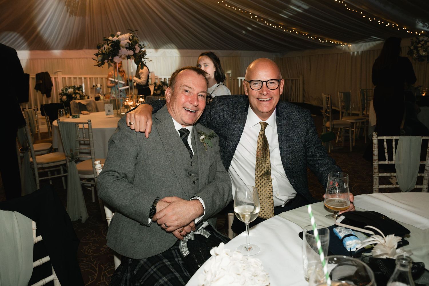 A collage of black and white wedding photos showing candid moments at a reception celebration.