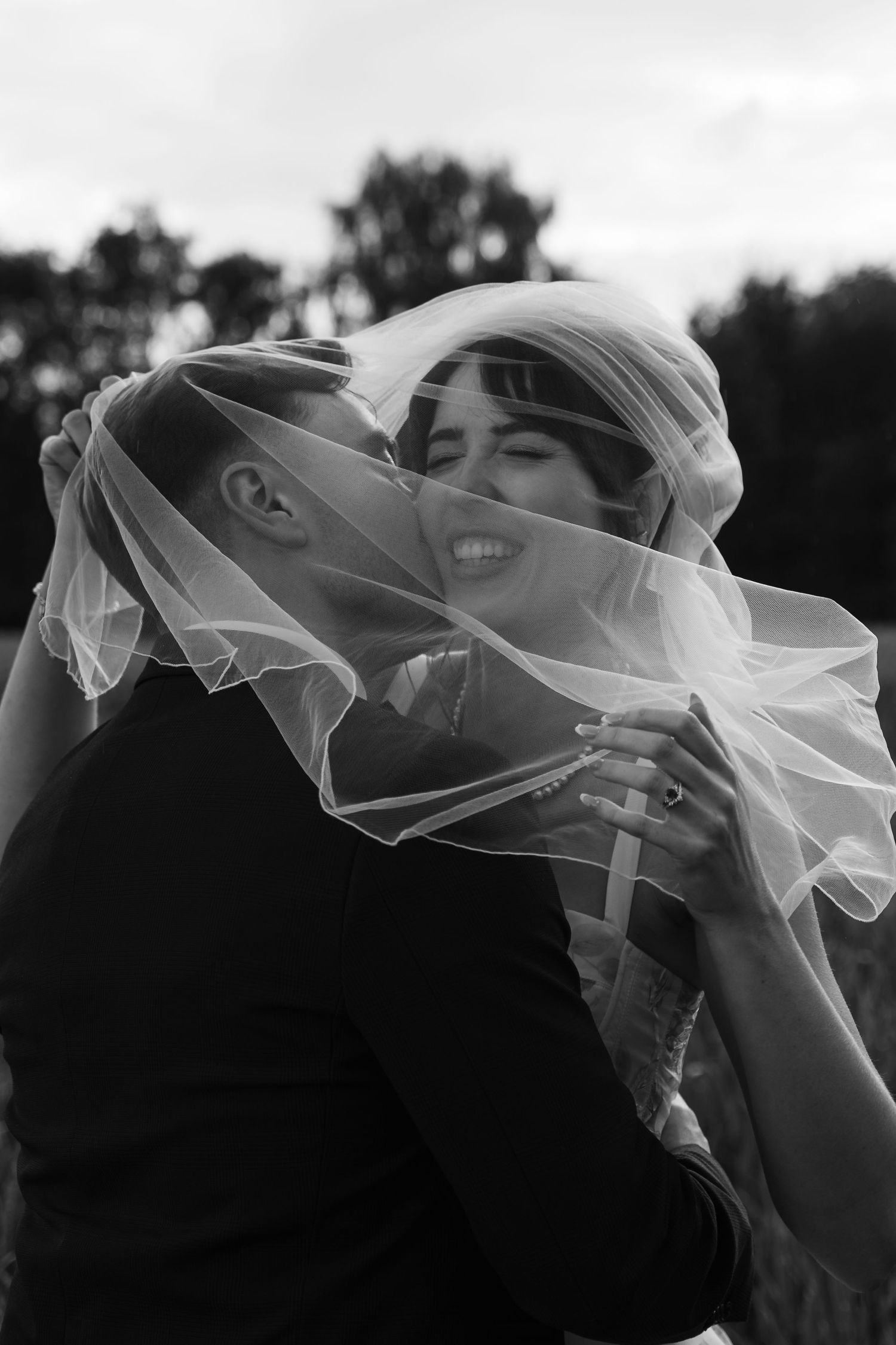 Black and white artistic shot of wedding veil flowing in the wind.
