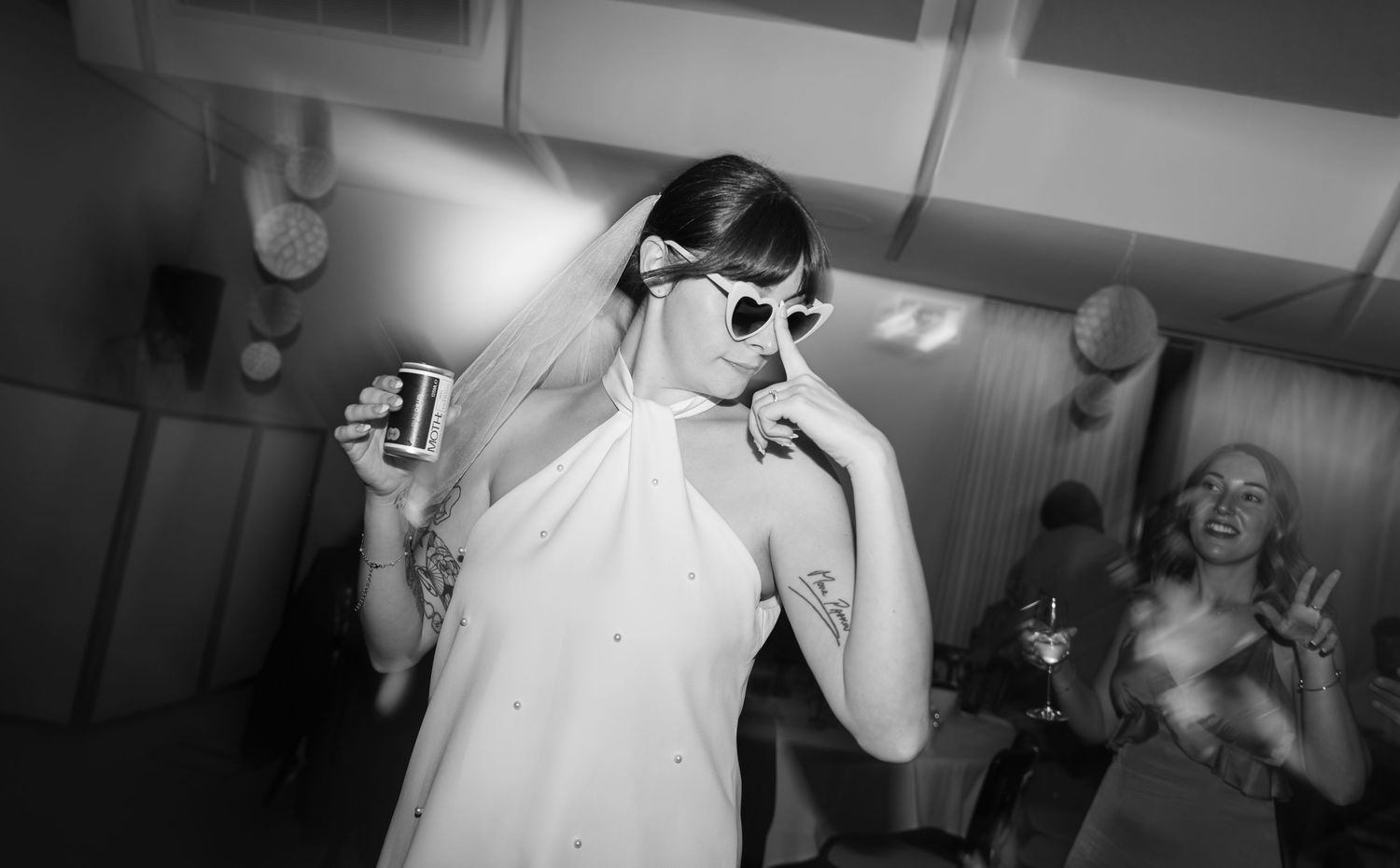 A series of black and white candid party photos showing people dancing and celebrating in an indoor venue.