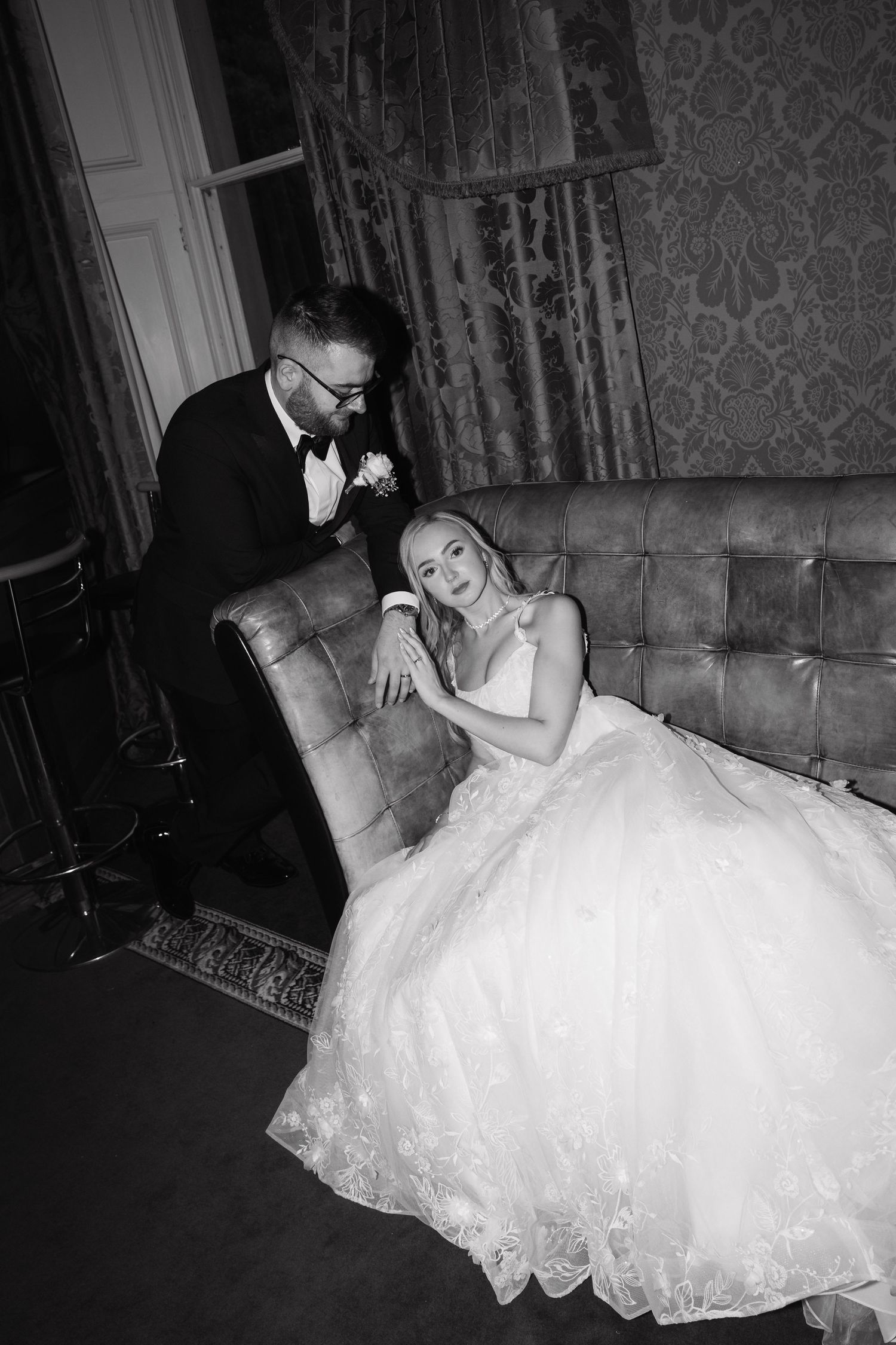 A series of black and white photos showing a bride in a flowing white wedding gown reclining on vintage furniture.