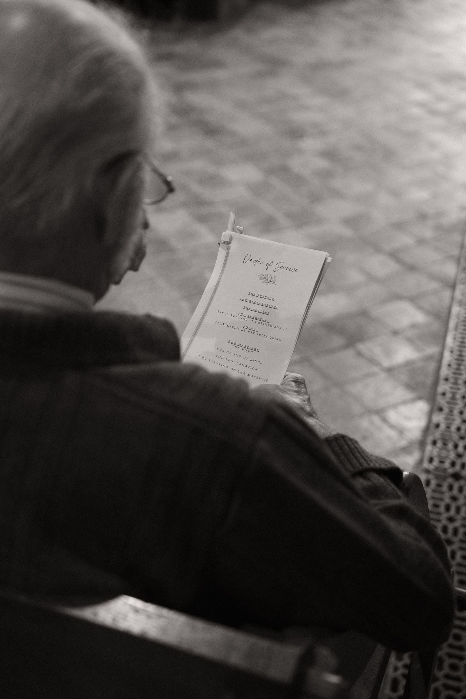 A black and white photograph showing someone reading a document in dramatic lighting.
