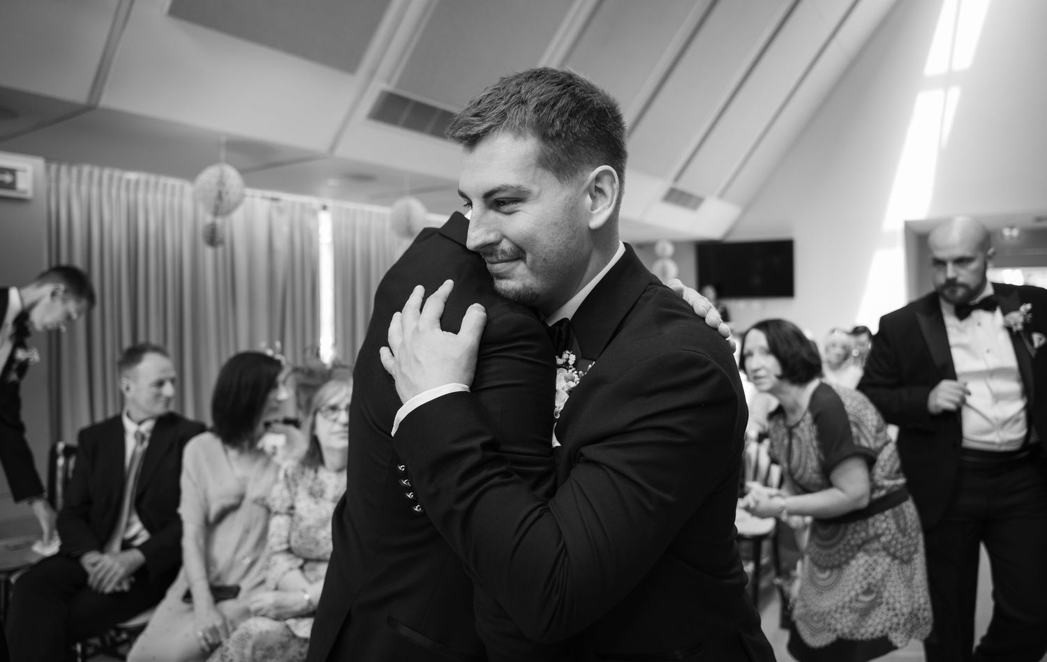 Wedding guests dancing and celebrating on a dance floor at an evening reception party.