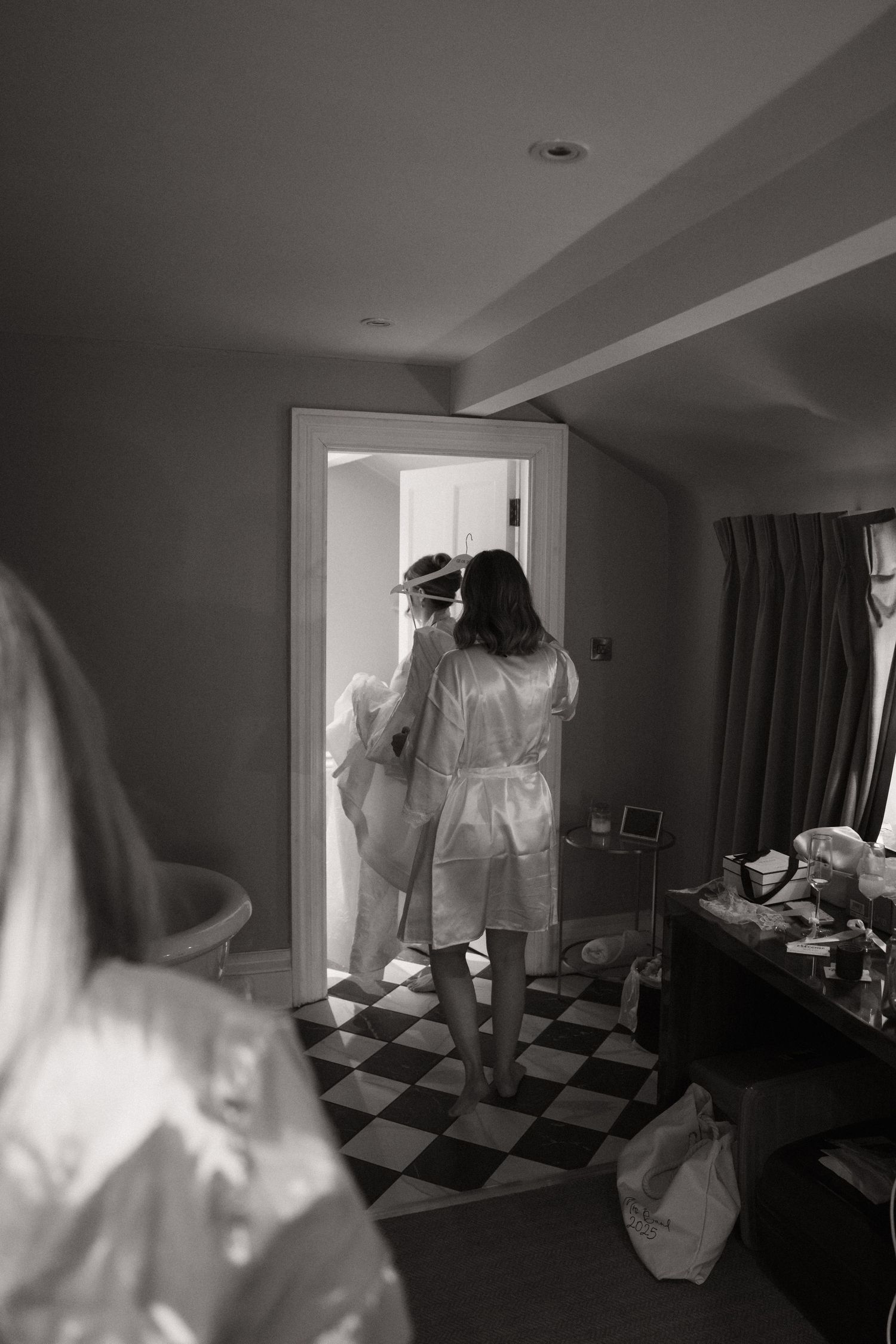 A ghostly figure in white moves through a dimly lit room with checkered flooring creating an eerie atmosphere.