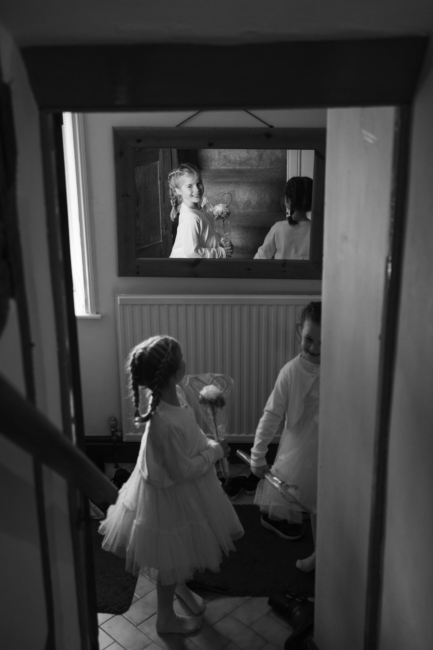 A series of black and white photographs showing a wedding preparation scene in a dimly lit room.
