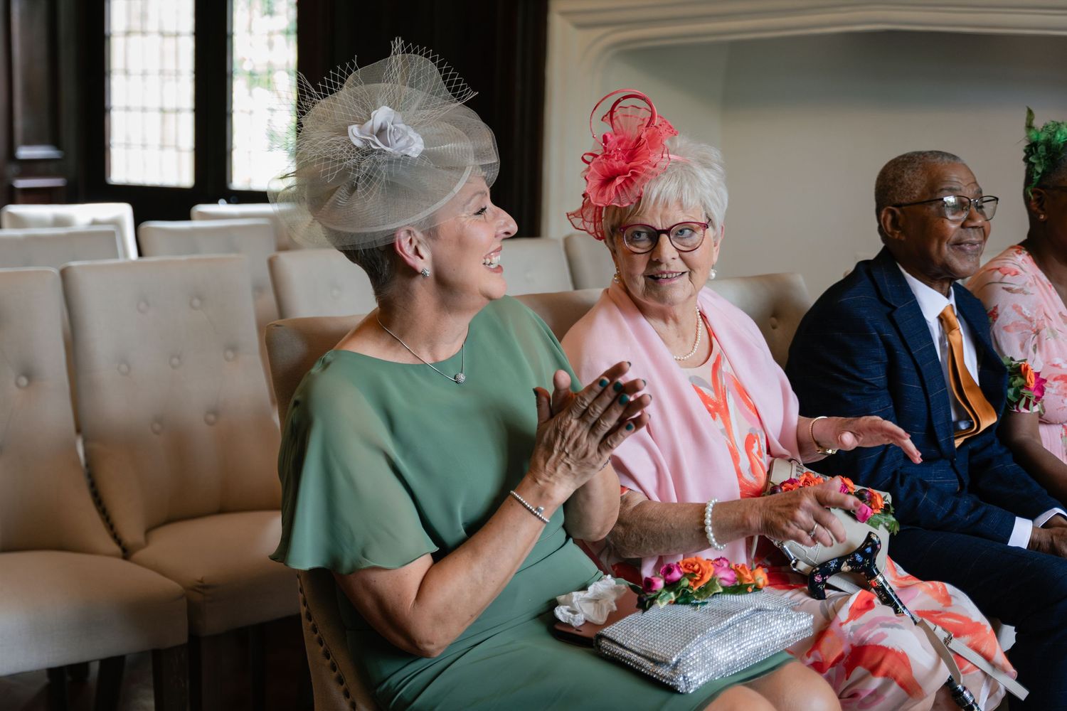 Group of seniors socializing and enjoying conversation together in a living room setting.