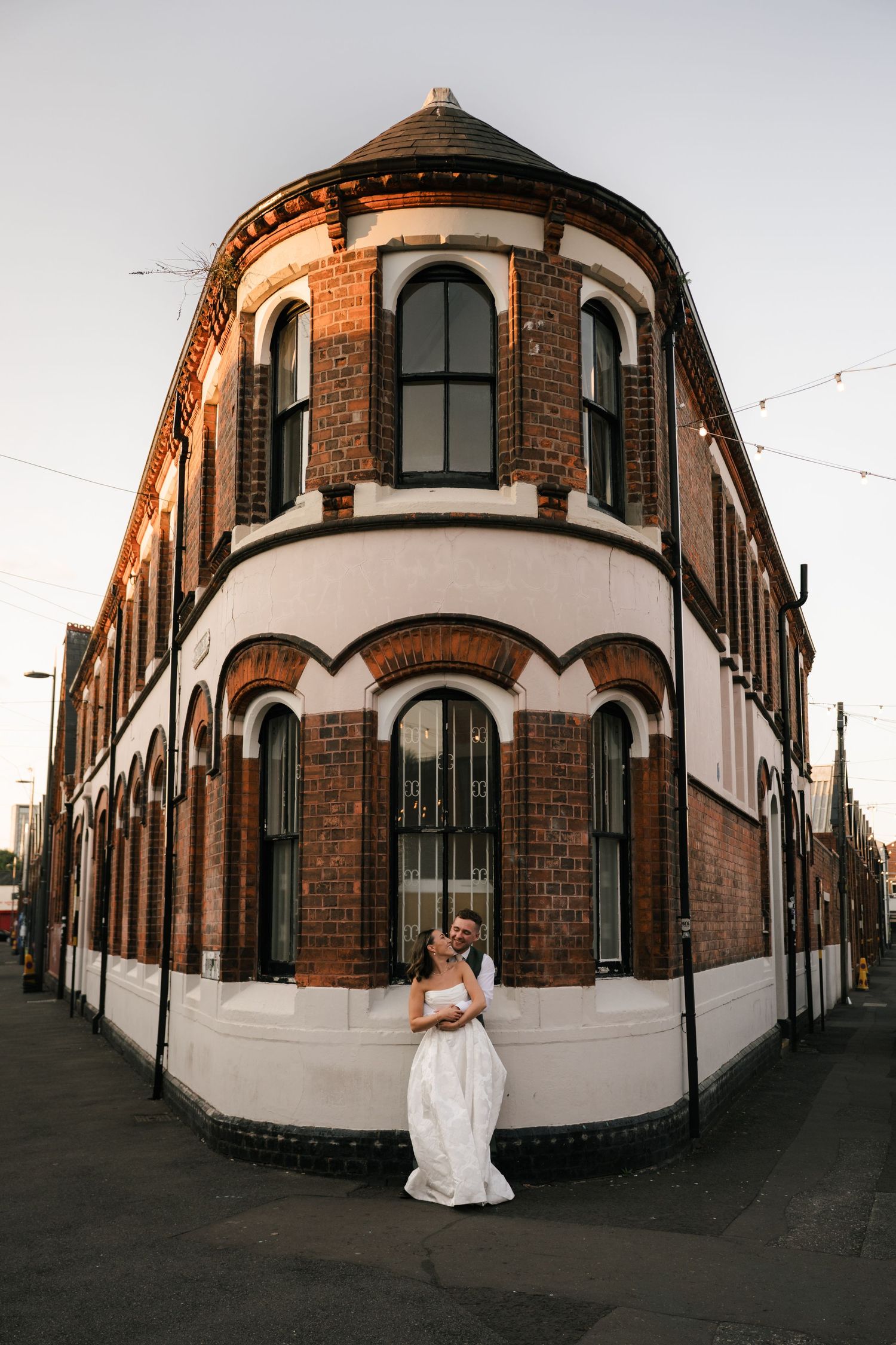 A panoramic series of architectural shots showing a curved brick building exterior with white walls and arched windows.