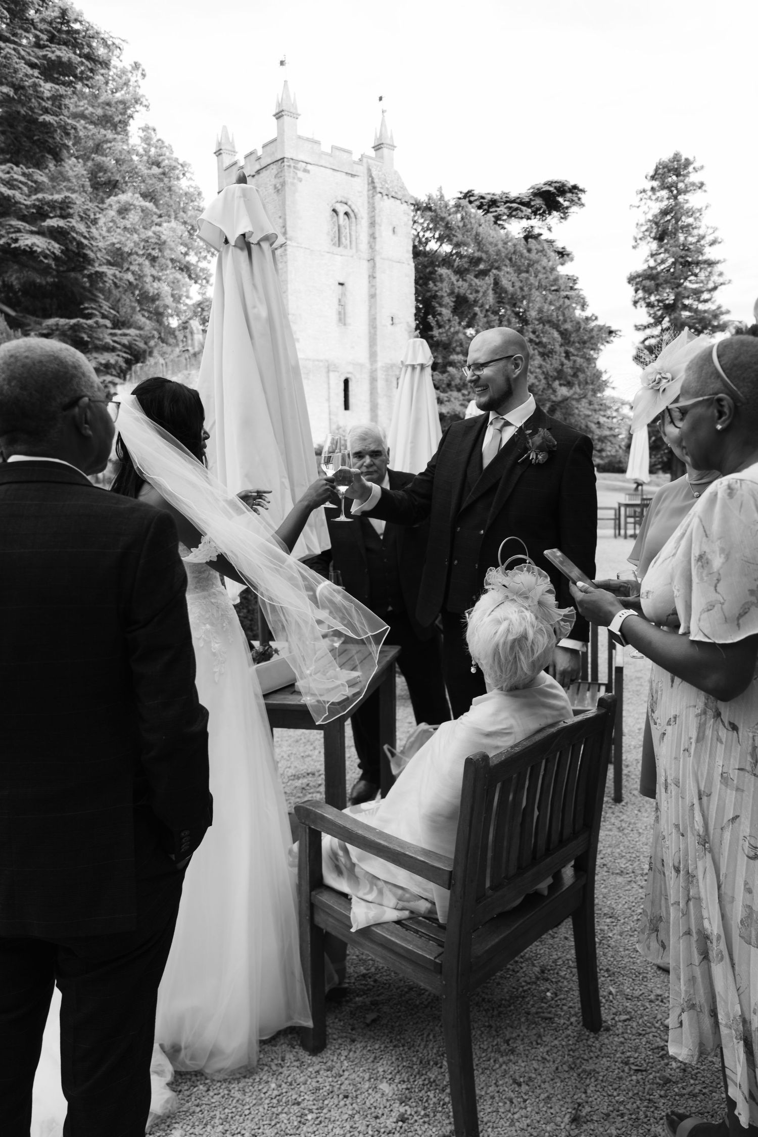 A series of black and white wedding photos showing a couple celebrating outside a church with a white tower.