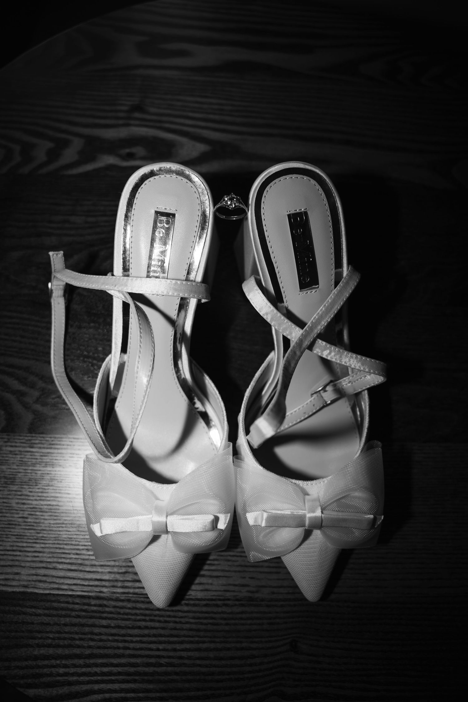 Elegant white high heel shoes shown from different angles in black and white photography.