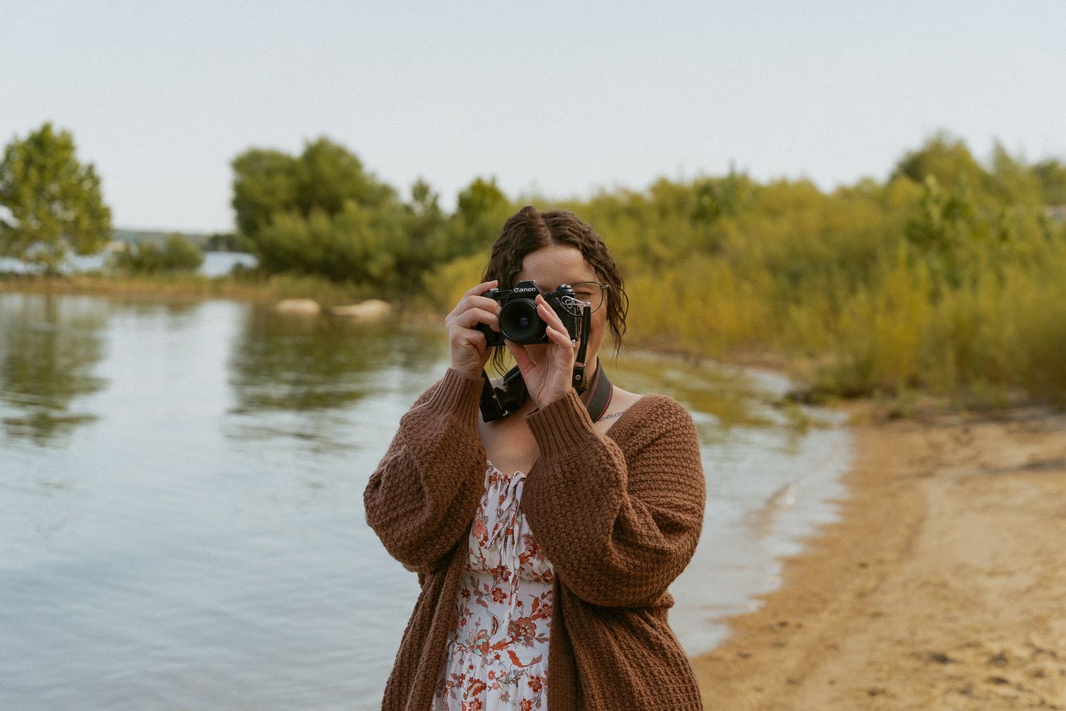 A scenic lakeside photography session with fall foliage in the background.