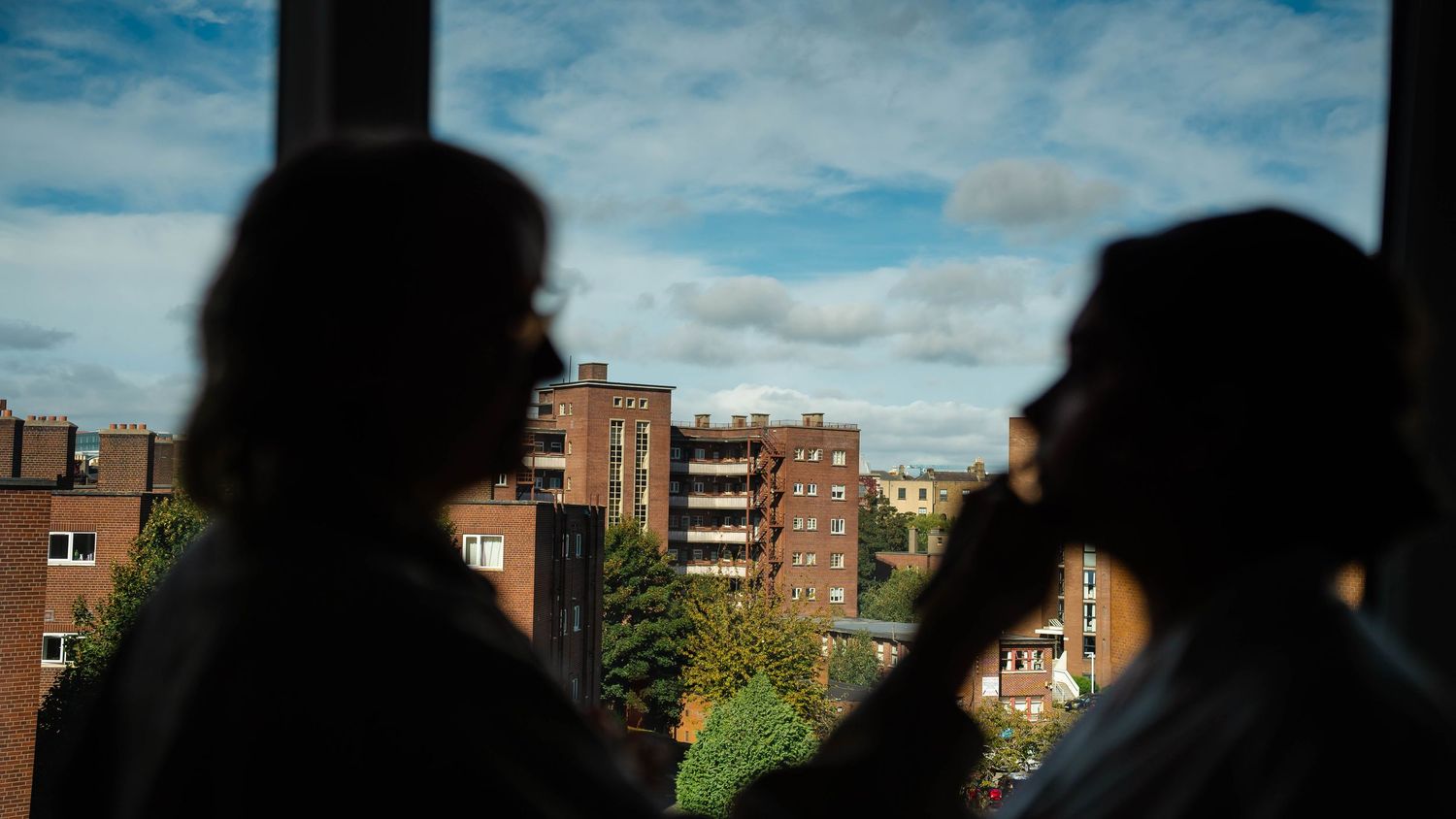 Silhouette of buildings against a cloudy blue sky.