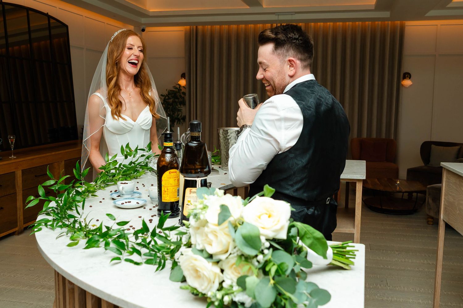 Wedding reception setup with floral garlands and elegant table settings.