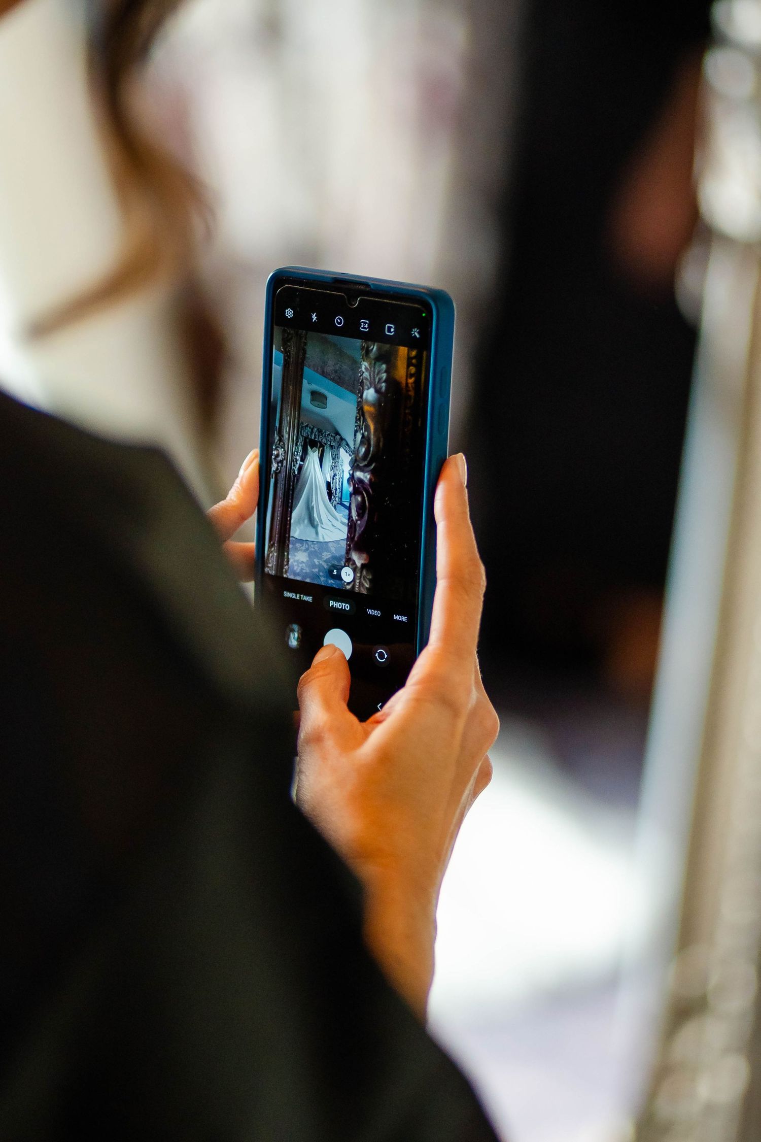 Someone holding a smartphone taking photos during an event.