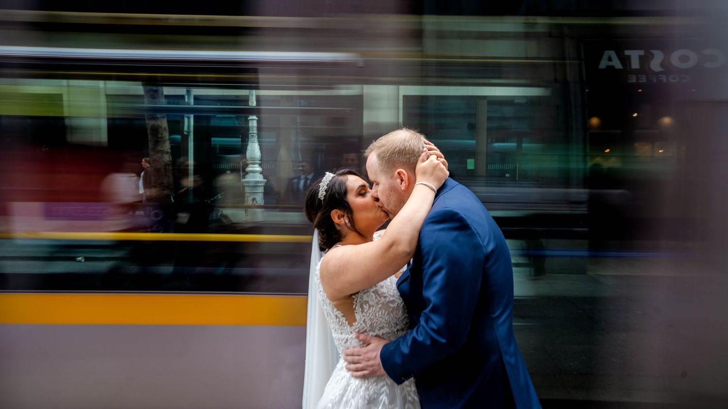 Couple walking through a modern glass-walled corridor with motion blur effects.