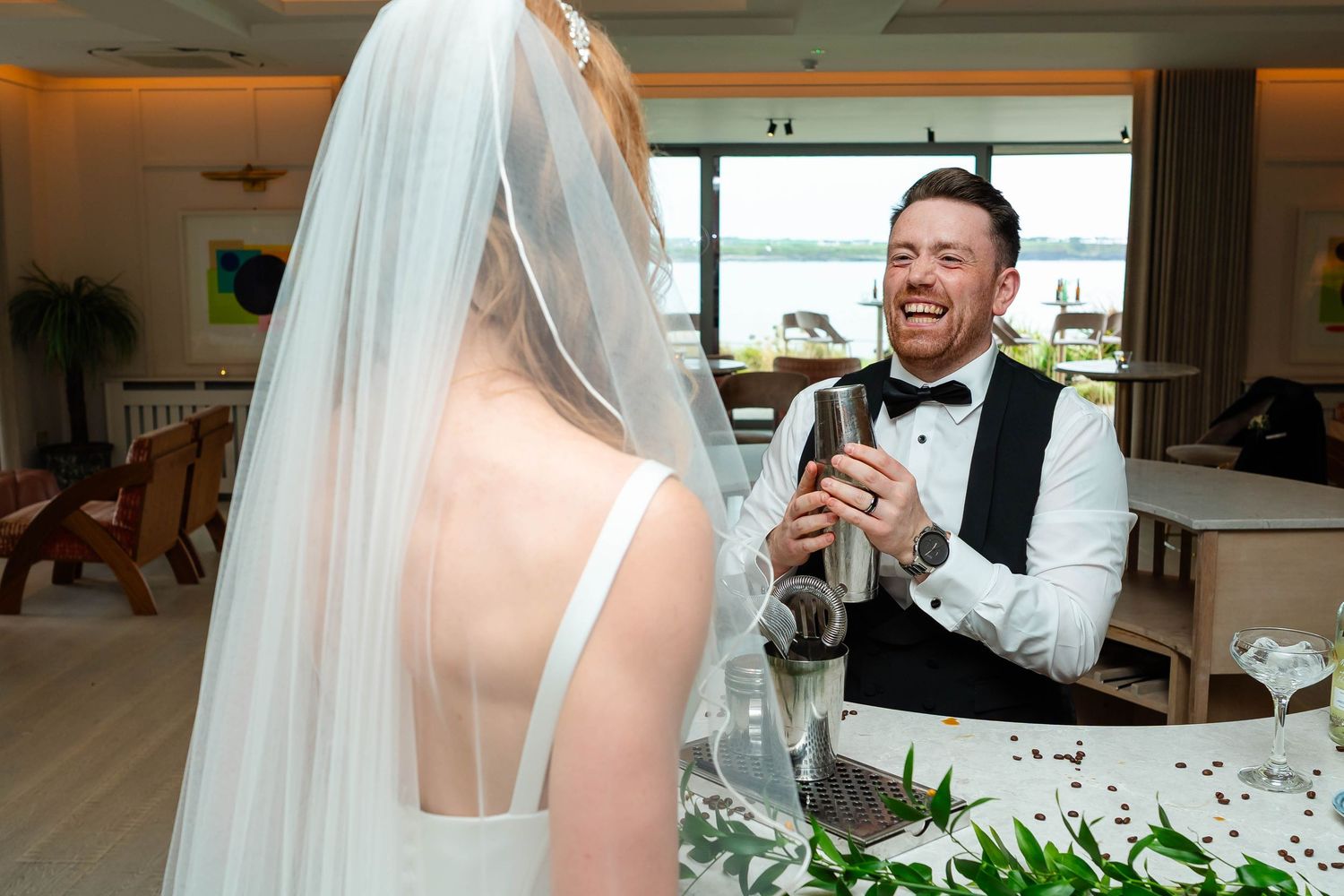 Wedding celebration moment with champagne and laughter in an indoor venue.