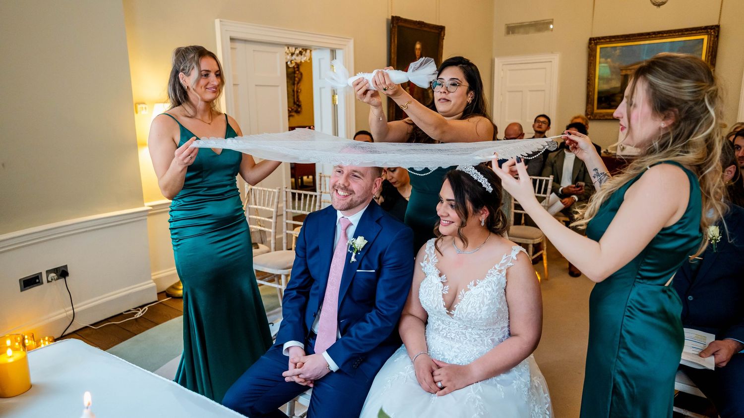 Wedding celebration panorama showing guests in formal attire gathered in an intimate venue setting.
