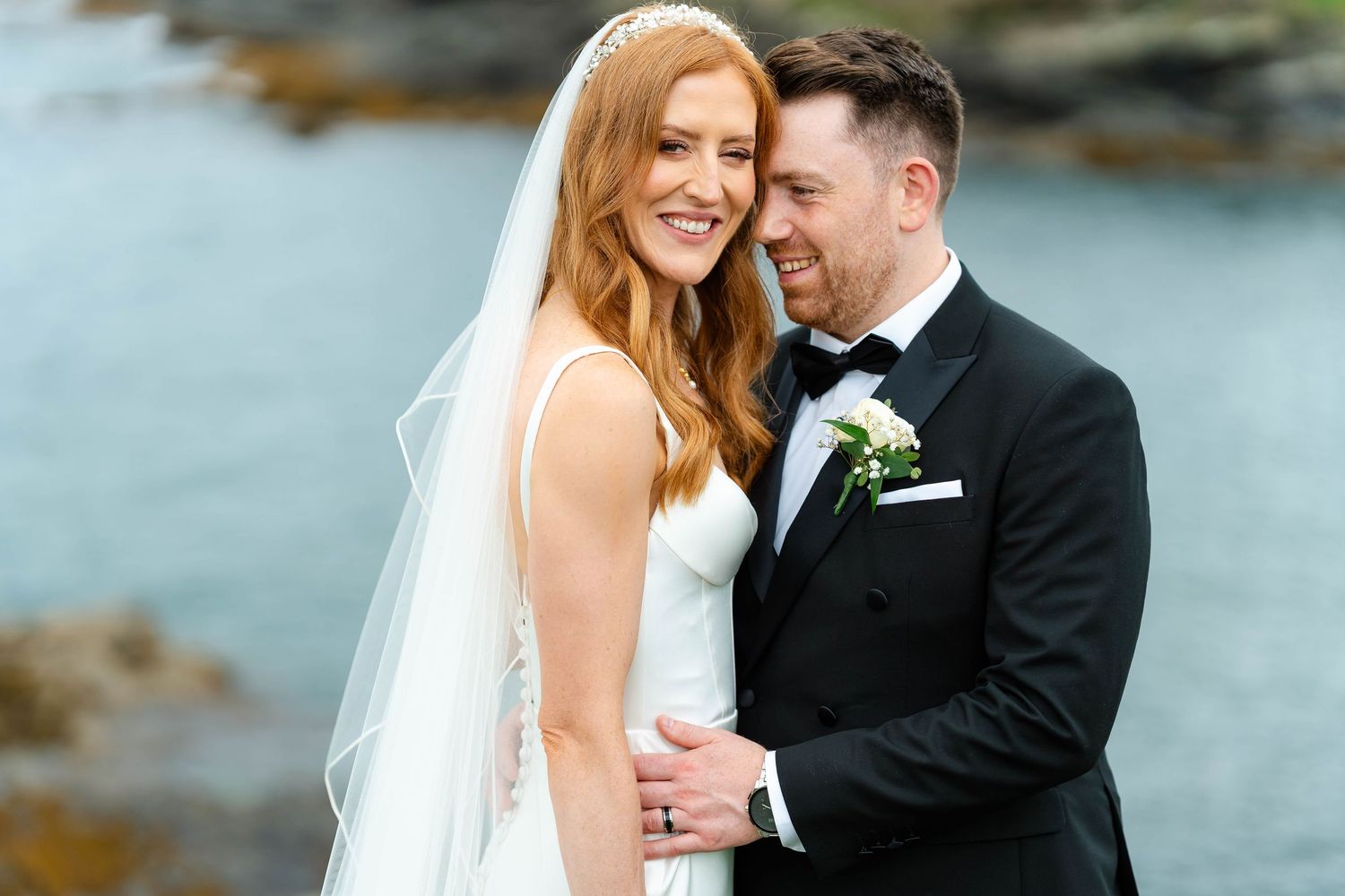Candid wedding moments photographed against a dramatic coastal landscape.