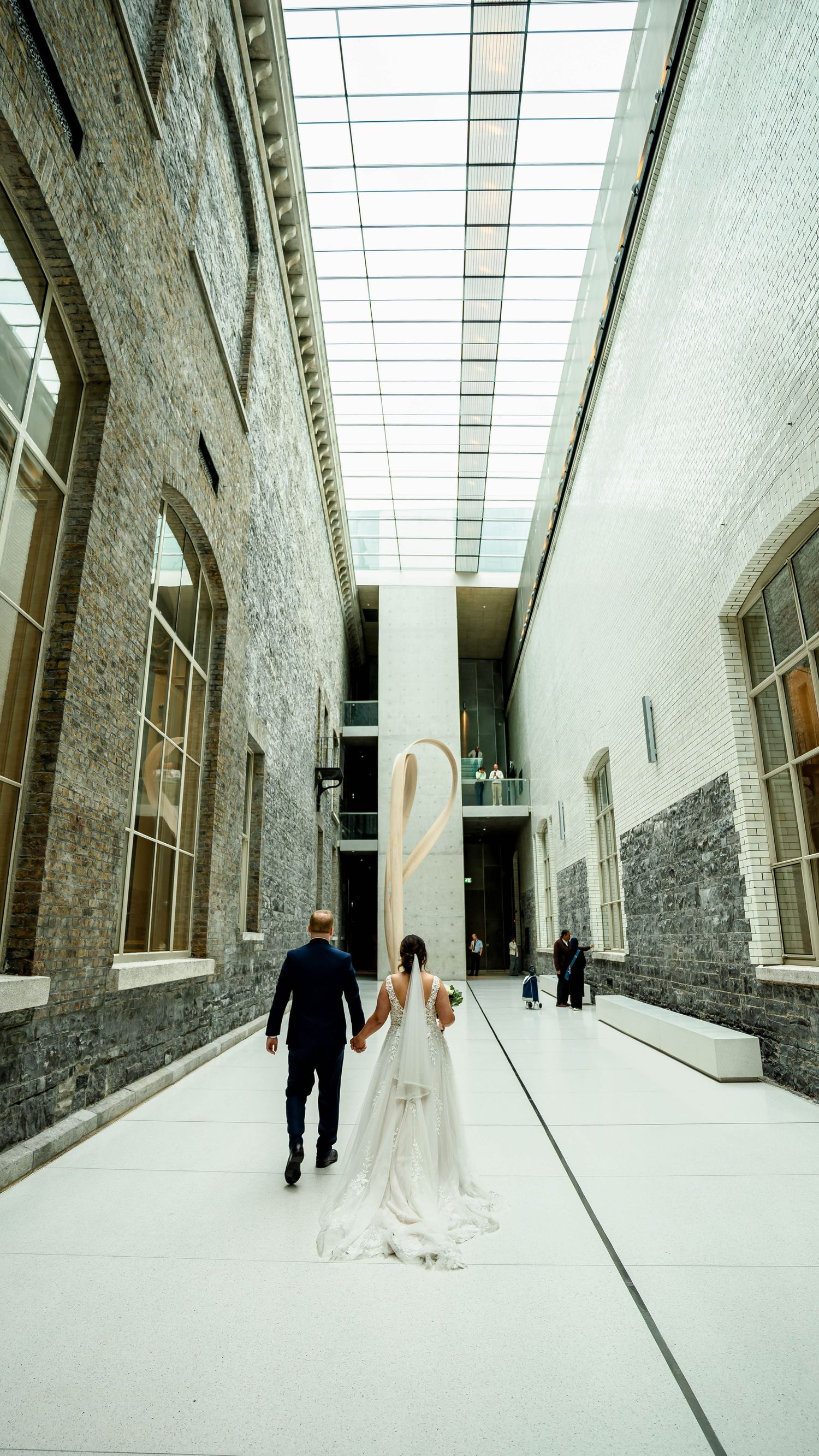 Modern white corridor with angular walls and natural lighting creates dramatic wedding photo backdrop.