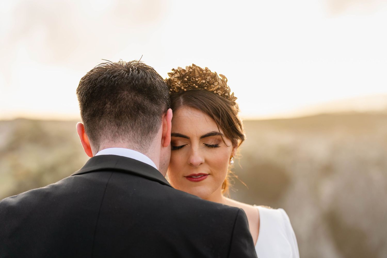 Intimate wedding portrait captured during golden hour with soft natural lighting.