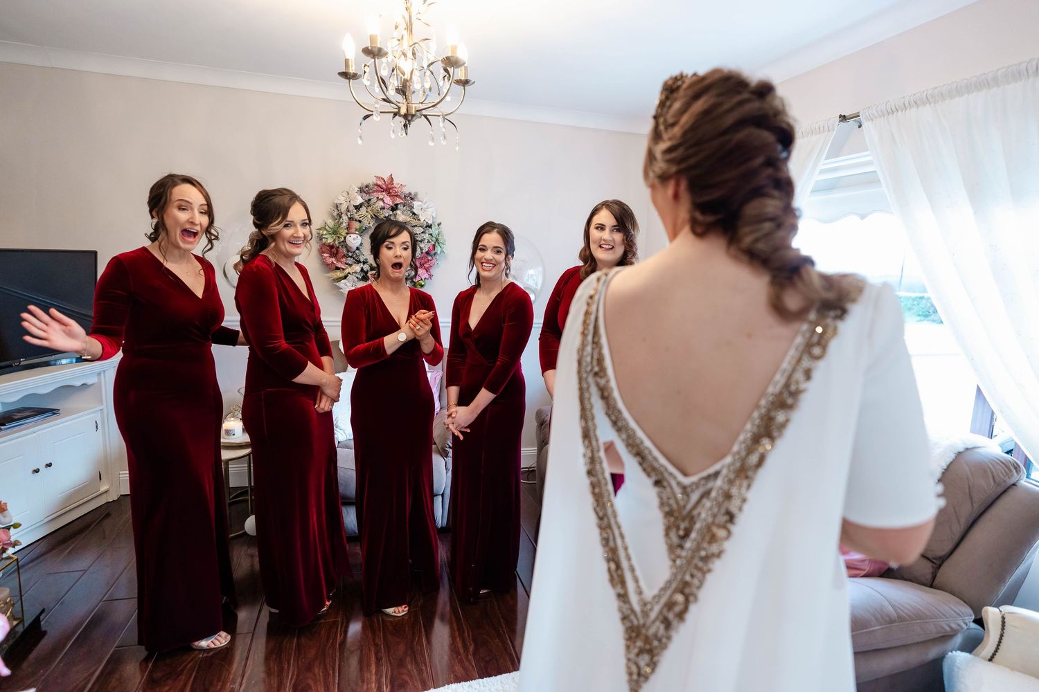 Wedding preparation scene showing elegant dresses hanging in a brightly lit room.