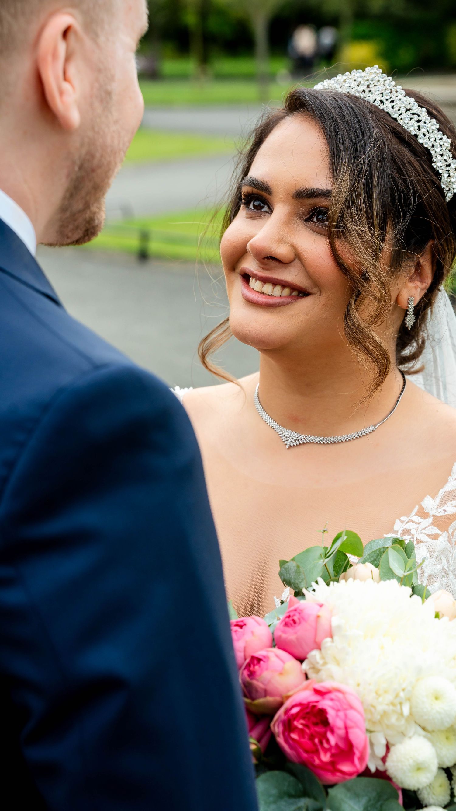 Closeup sequence of a bride in a white dress and tiara holding a pink and white bouquet.