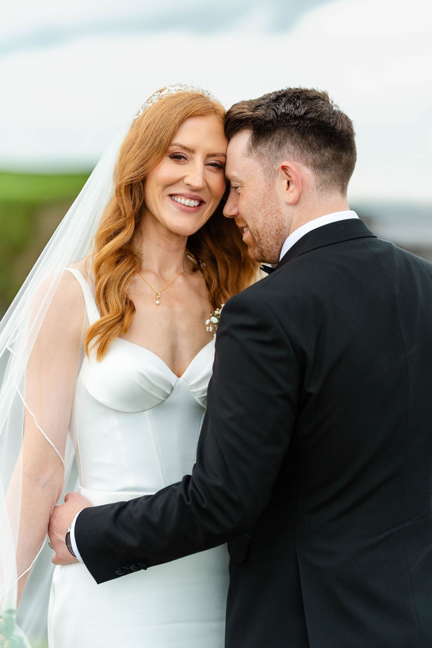 Intimate wedding moment shared on a coastal clifftop with ocean views.