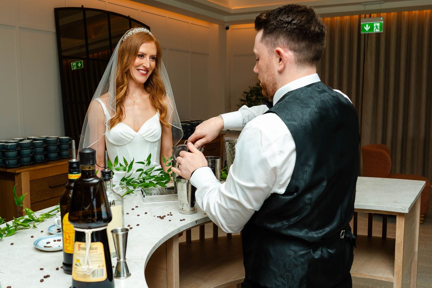 An elegant reception venue with mood lighting and decorative greenery.