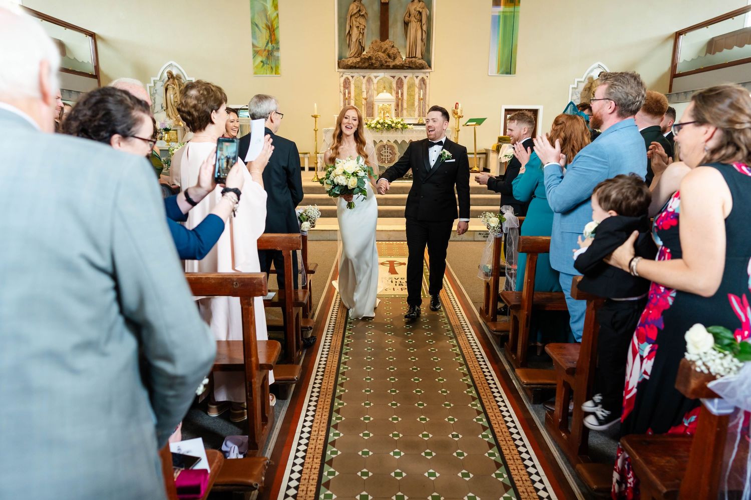 Church interior with religious artwork and guests gathering for celebration.