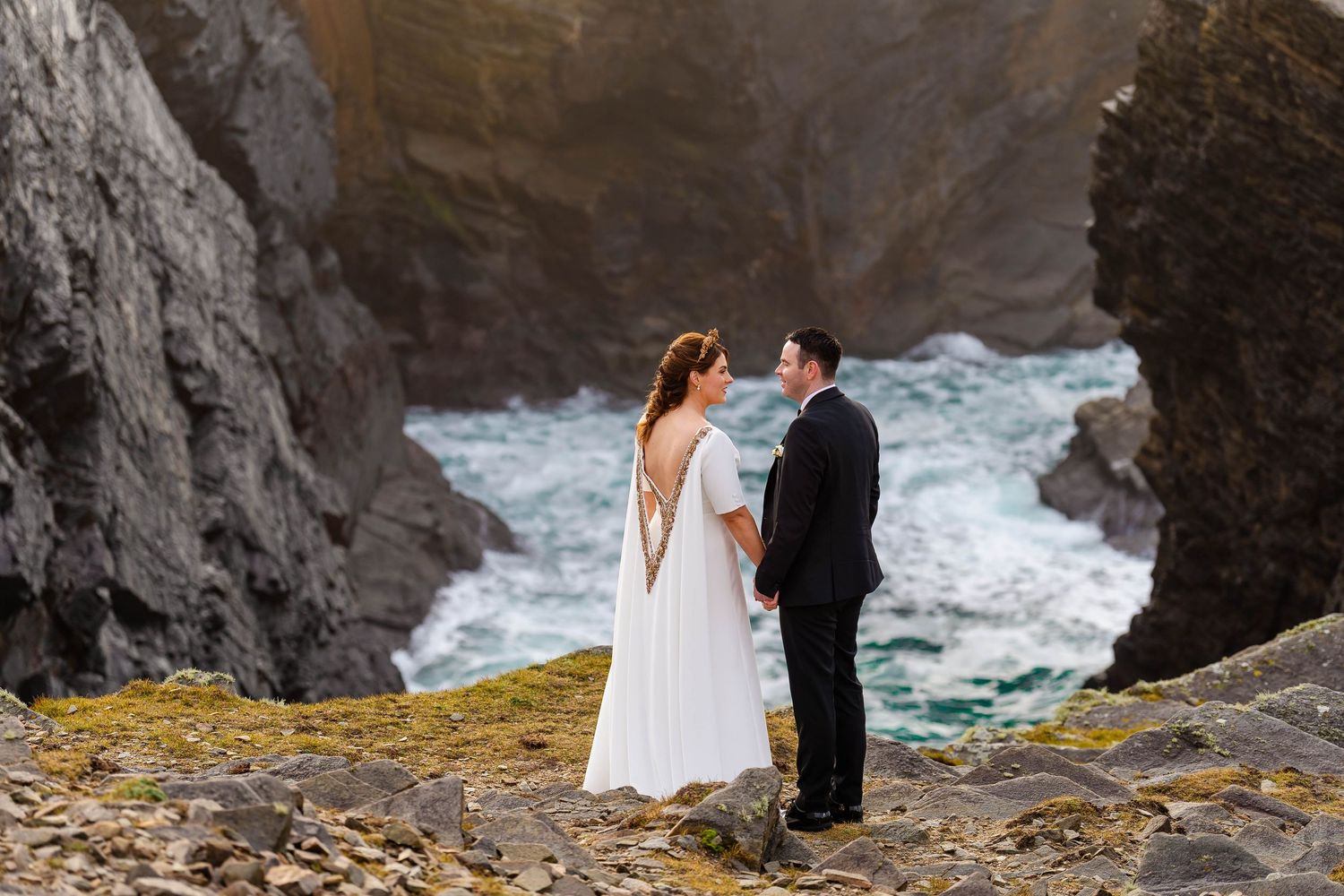 Dramatic coastal cliffs and crashing waves create stunning wedding photo backdrop.