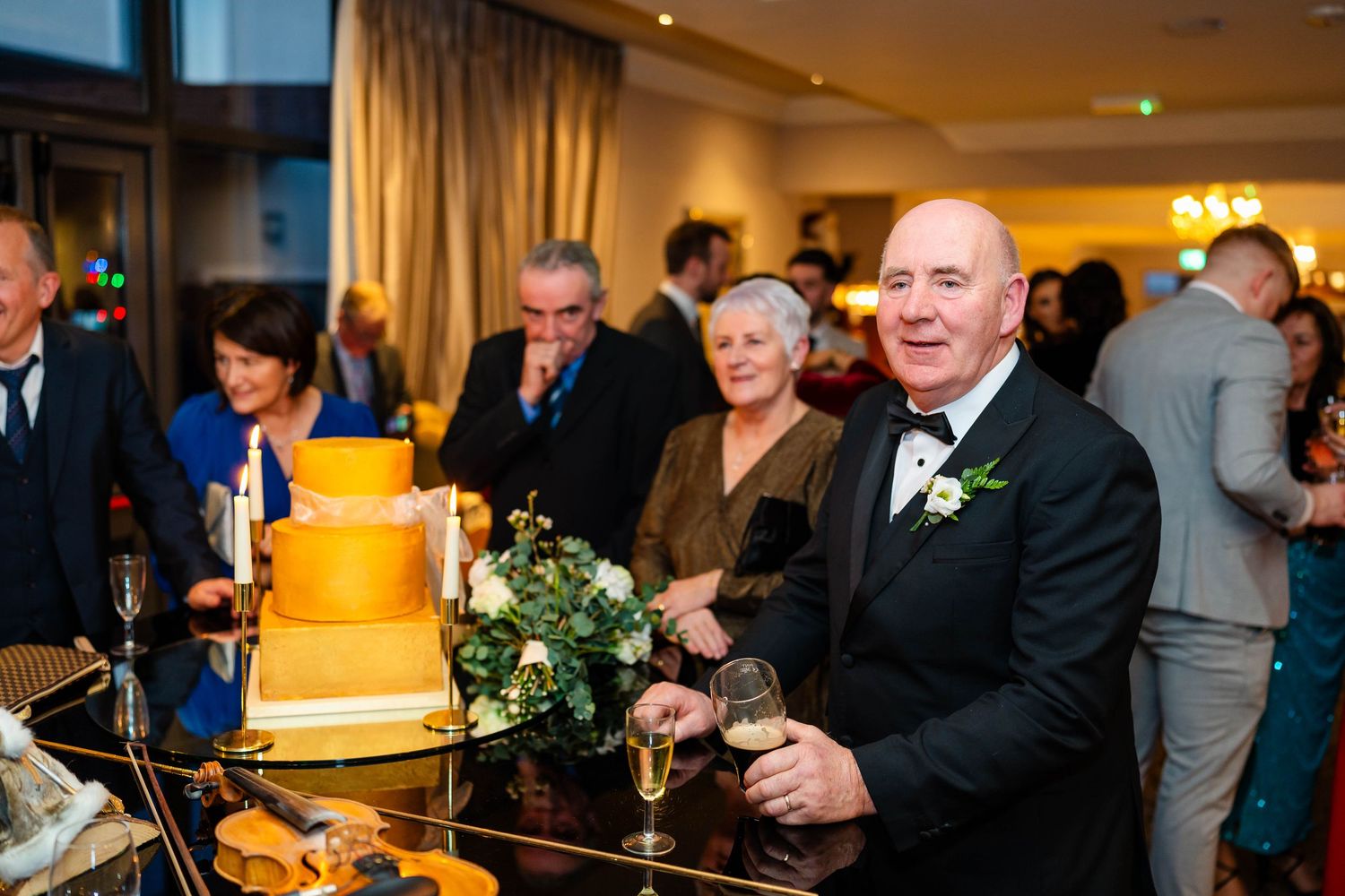 Evening reception event with guests gathered in an elegant indoor venue with ambient lighting.