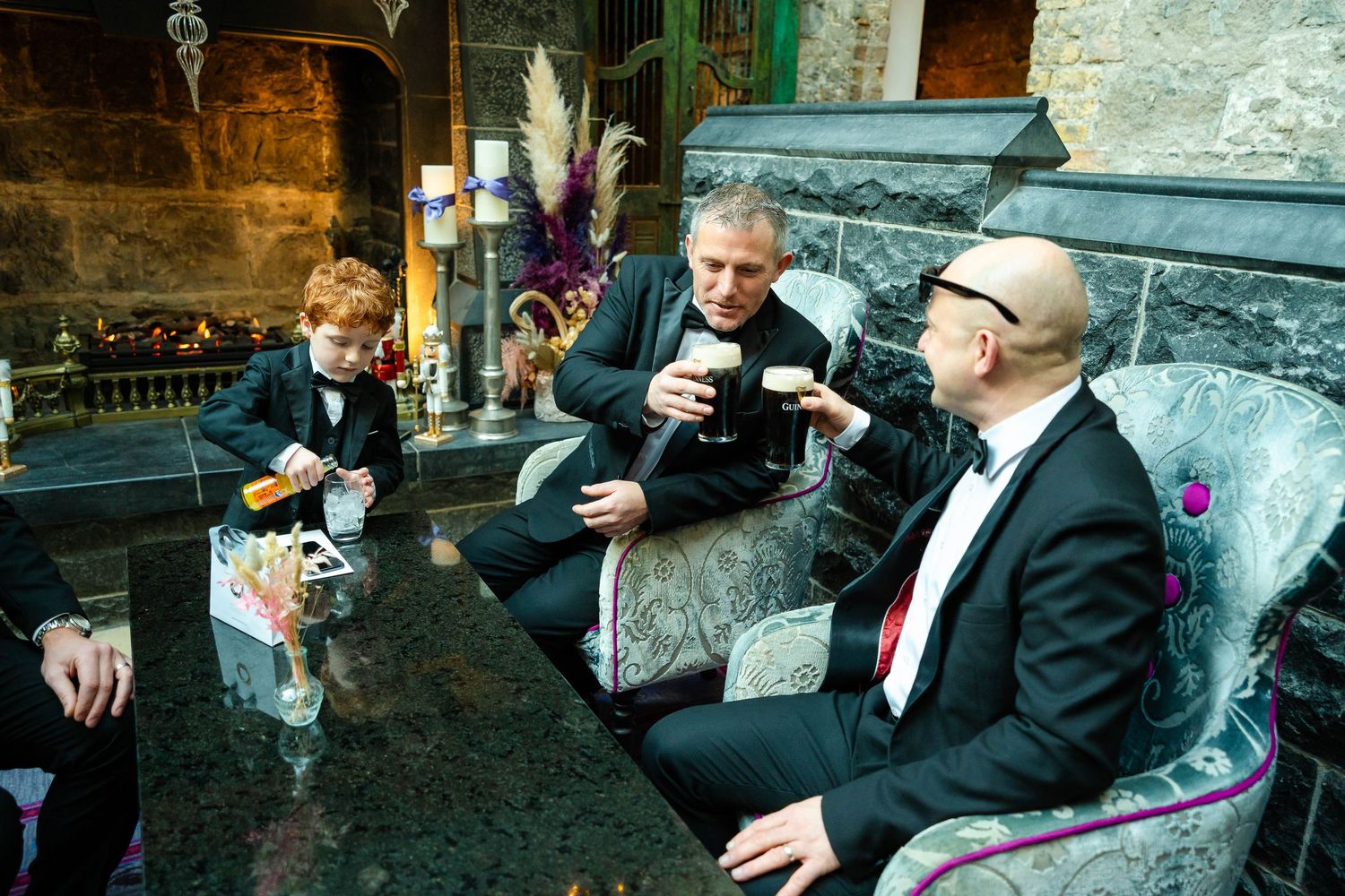 Group sitting on vintage furniture in formal attire during an event.