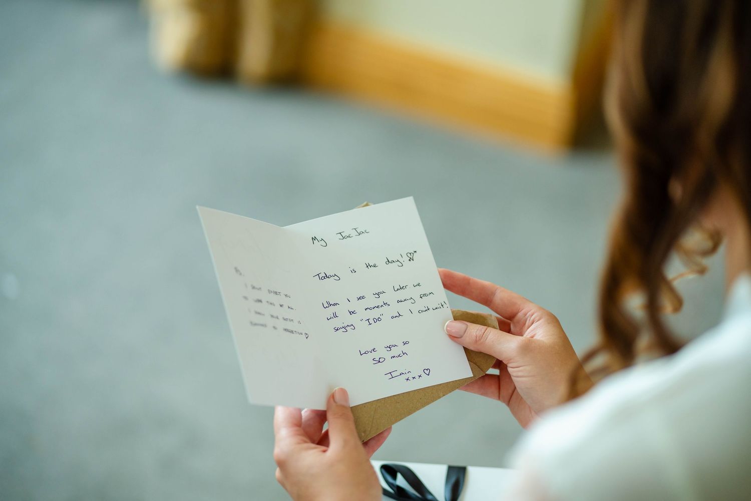 Person reading handwritten note or letter with soft focus background.