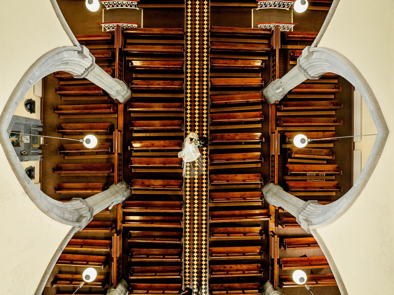 Symmetrical view of wooden church ceiling with architectural beams and lighting.